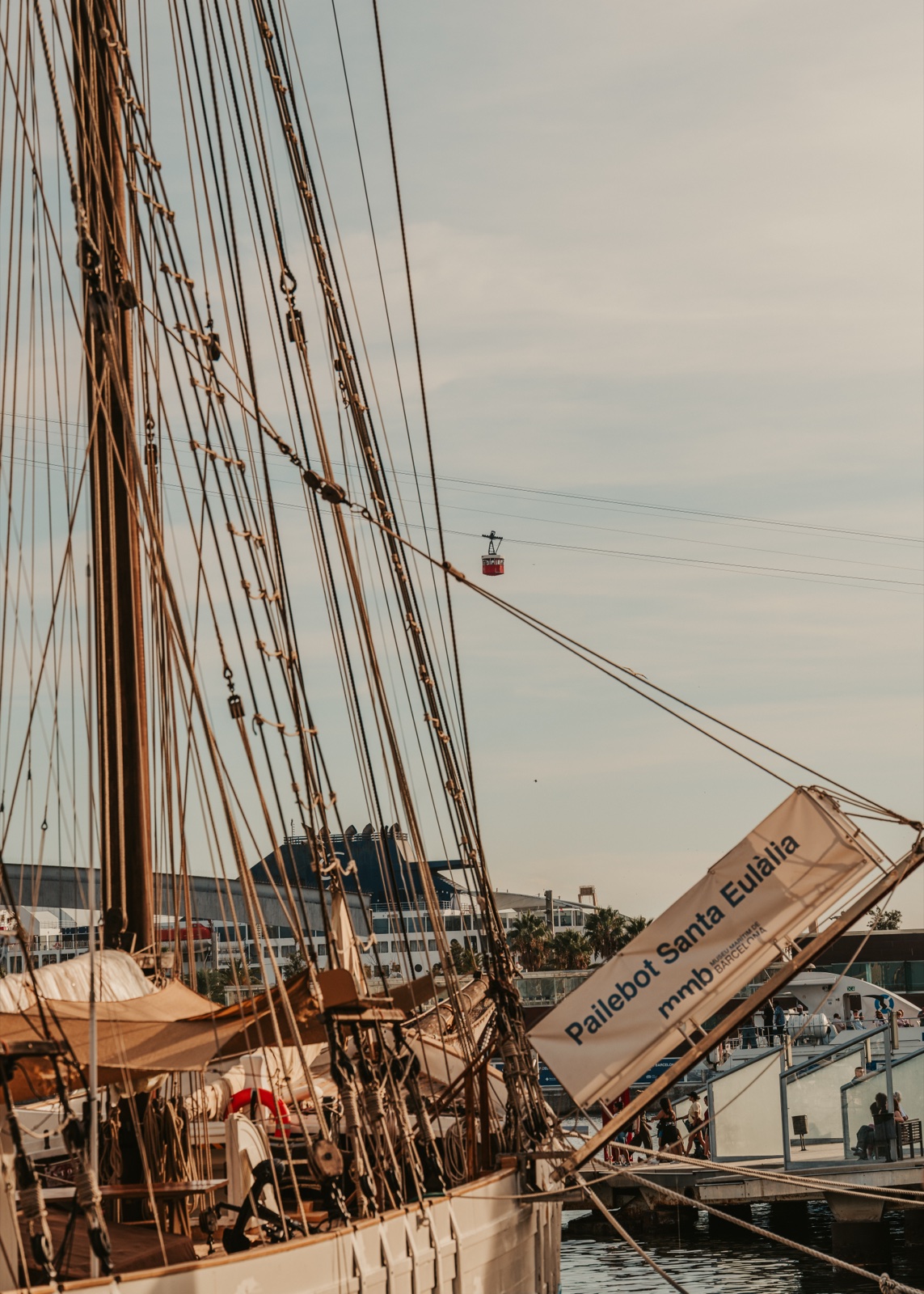 The schooner Santa Eulàlia moored in the port, with the cable car crossing above